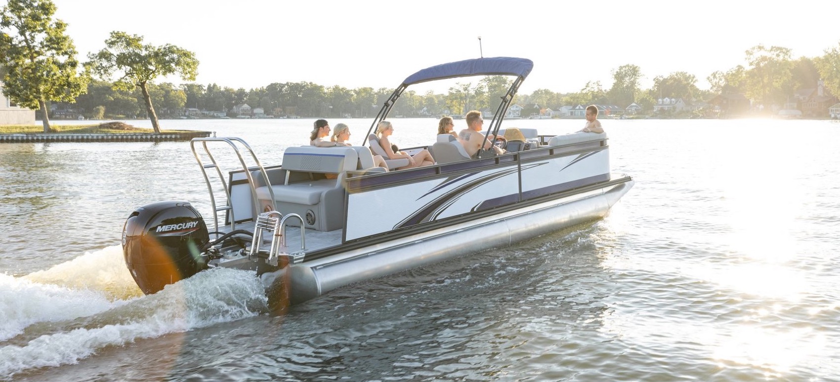 Family cruising on a pontoon boat at sunset
